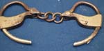 pair%20of%20steel%20handcuffs%20with%20inside%20ratchet%20and%20chain%20links